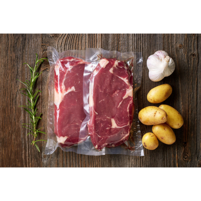 Chamber Vacuum Sealer Bags With Steaks, Potatoes, Garlic, And Rosemary On Wooden Background
